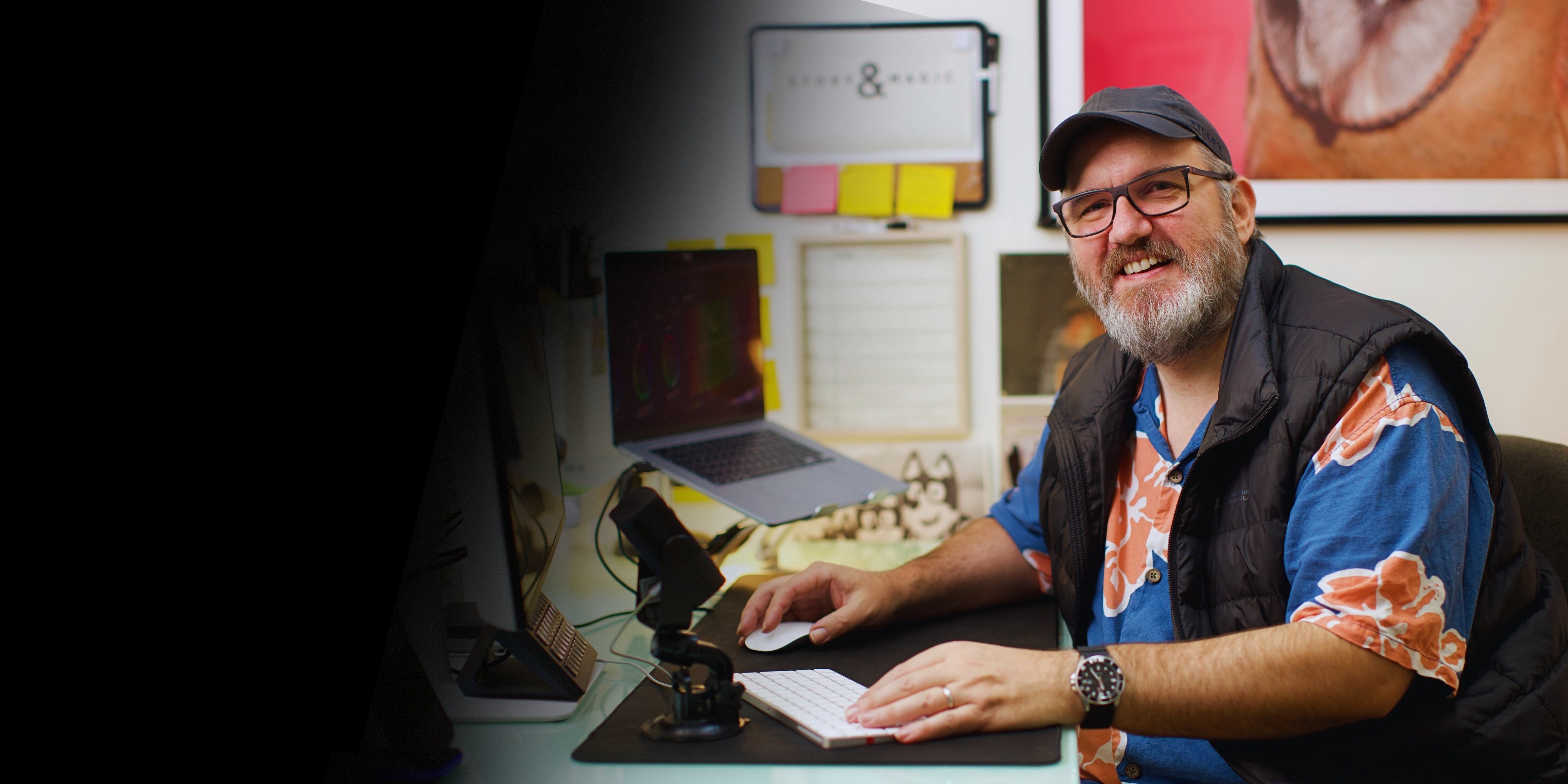 Andy Sutton smiling at his edit desk, hand on the mouse