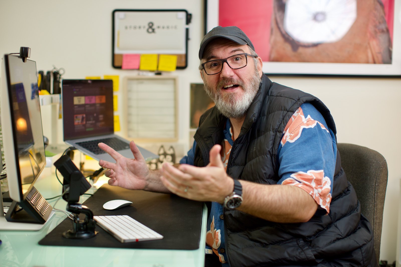 Andy mid-conversation at his desk, hands open, explaining something